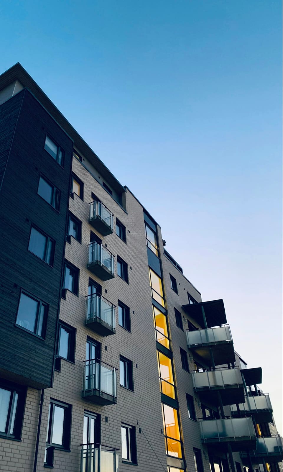 Multi-storey residential building with full-height black-framed windows